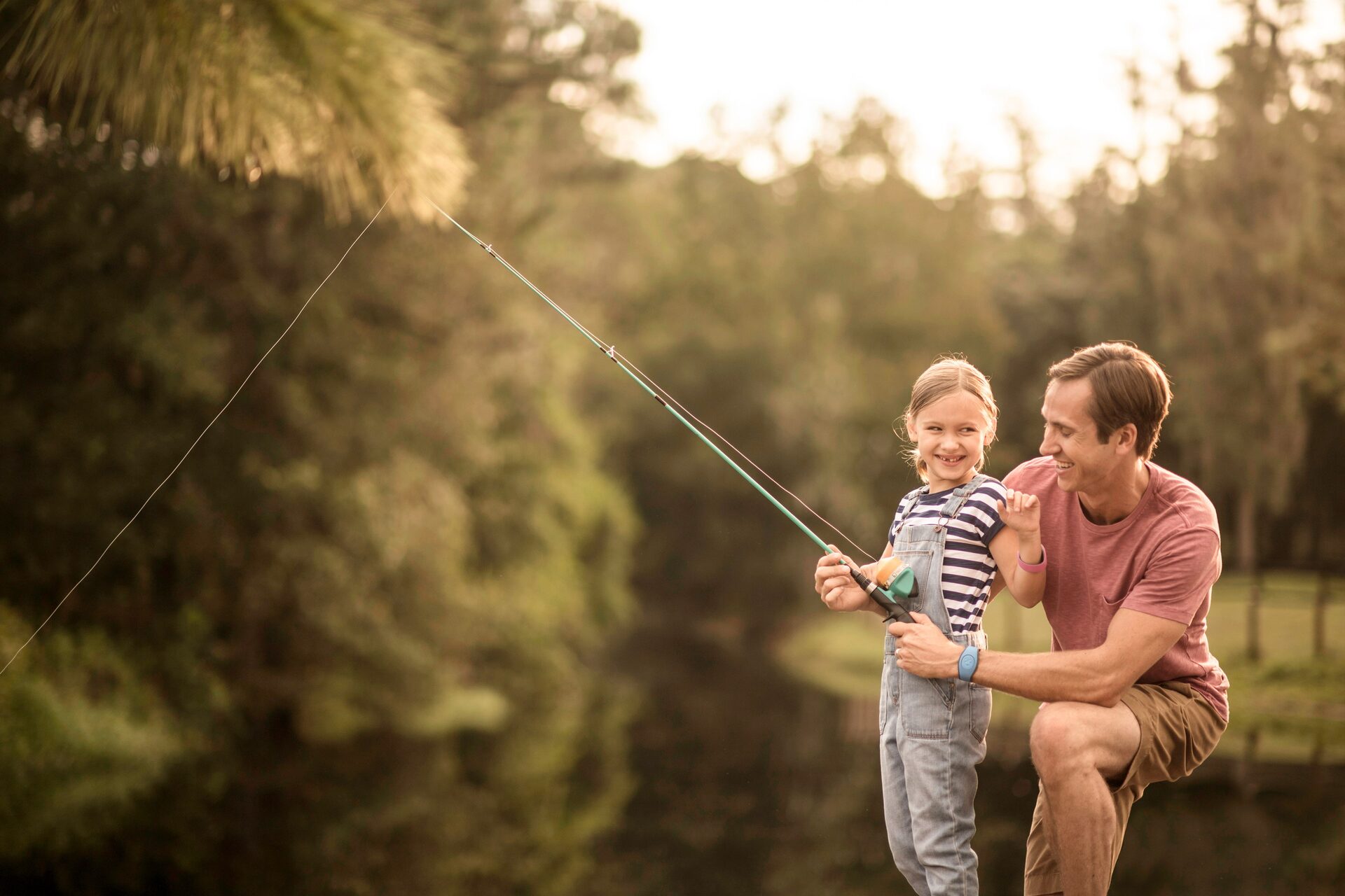 A father and child cast a line at the water’s edge, backlit in the late-day sun, at Disney’s Fort Wilderness Resort & Campground. A father and child cast a line at the water’s edge, backlit in the late-day sun, at Disney’s Fort Wilderness Resort & Campground.