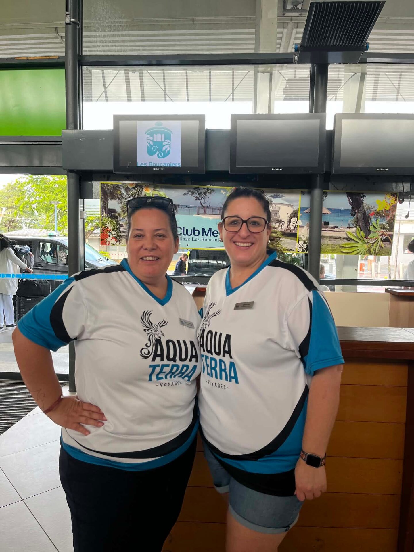 Deux conseillères en chandail Aqua Terra à l’accueil de l’aéroport de Martinique