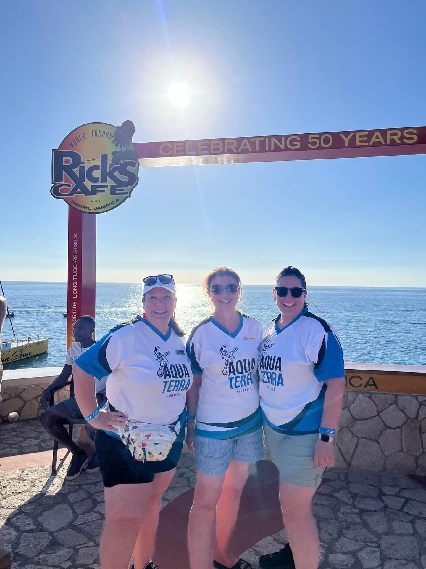 Trois conseillères Aqua Terra sous l’enseigne du Rick’s Café à Negril