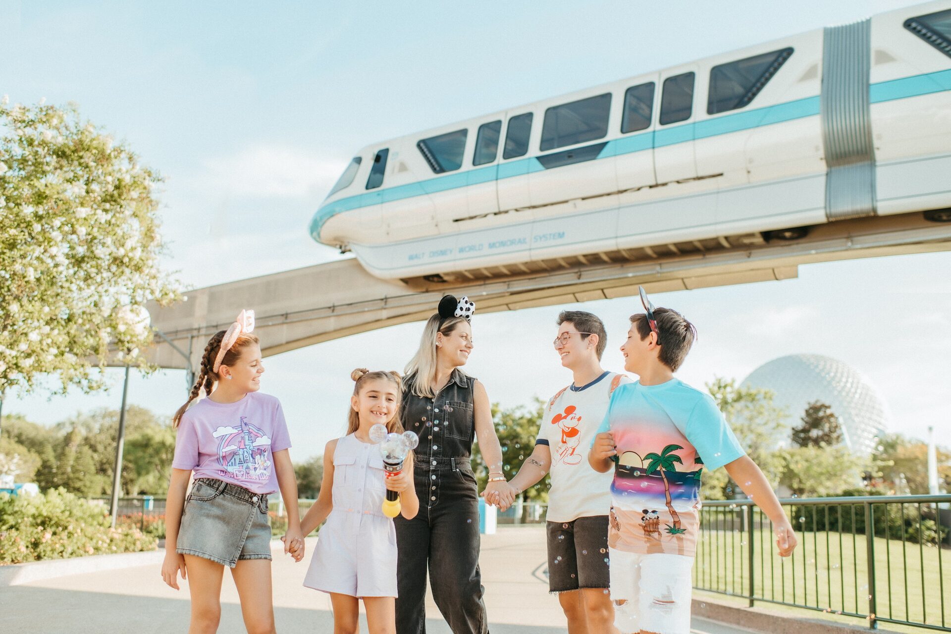 Une famille marche sous le monorail de Walt Disney World, près de l’entrée d’EPCOT, en Floride Une famille marche sous le monorail de Walt Disney World, près de l’entrée d’EPCOT, en Floride